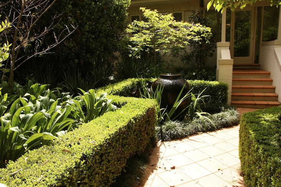 Bubbling fountain and crisp hedging make an inviting entrance